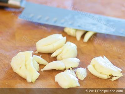 Garlic crushed and peeled on a cutting board