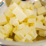 Cut the butter into small pieces and put into a large bowl.