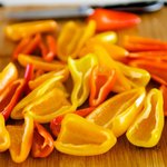 Remove the stems from the baby sweet bell peppers. 