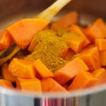 Add papayas and curry powder into pot.