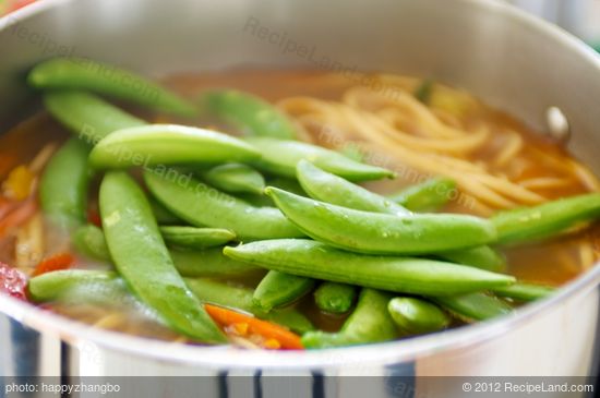 sugar snap peas, scallions, and half of the cilantro into the pot.