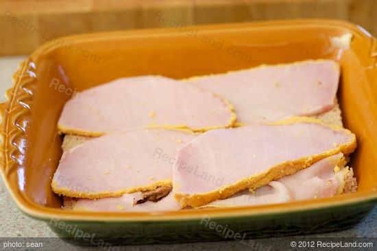 Cover bread with cooked back bacon slices or ham slices. 