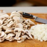 Chop up the onions and slice up the mushrooms.