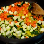 Stir in yellow bell peppers, carrots, and zucchini, 