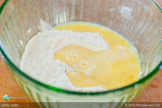 Add lightly beaten eggs and water to the sifted flour mixture