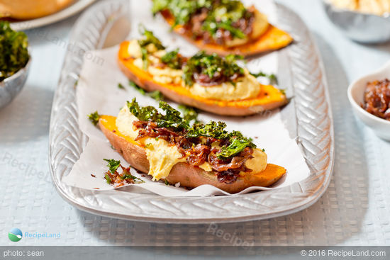 Sweet potatoes topped with caramelized onions, hummus and crispy kale chips