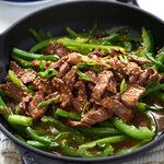 Quick, easy marinated ginger beef strips. Asian inspired steak strips glazed in a ginger honey soy sauce with green peppers served over rice.