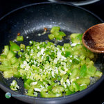Scallions and diced green bell peppers in a skillet