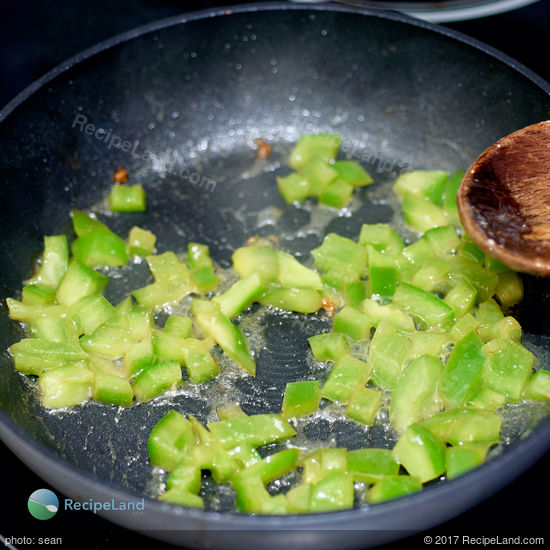 Green bell pepper cooking in non-stick skillet