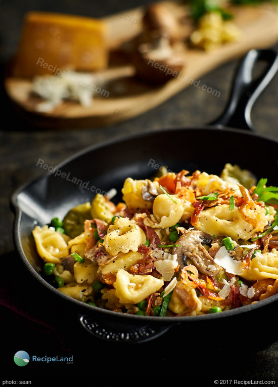 Tortellini with mushrooms, peas and prosciutto in a white cream sauce.