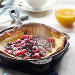 An impressive yet easy to make baked breakfast pancake that achieves a massive height and is filled with berries and yogurt.