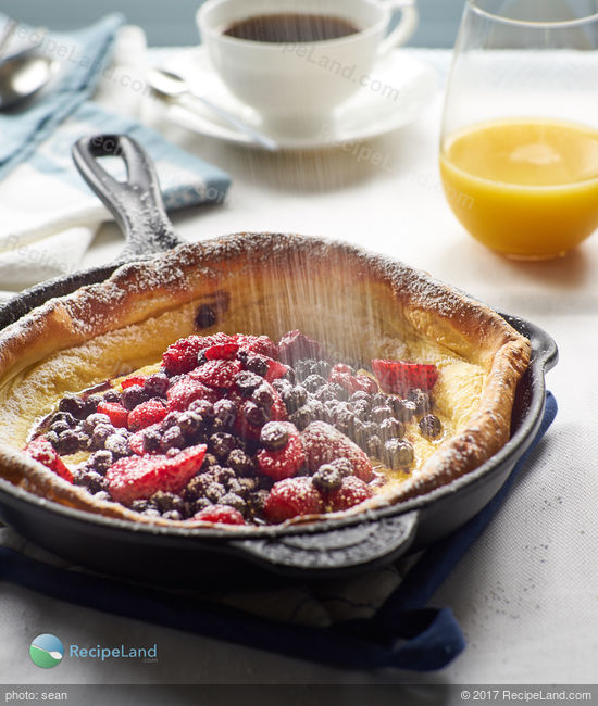 An impressive yet easy to make baked breakfast pancake that achieves a massive height and is filled with berries and yogurt.
