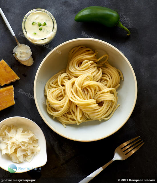 Freshly cooked spaghetti arranged in a <a href="/how-to/ballistic-about-bowls-338" title="Ballistic about bowls - Essential kitchen bowls with reviews">bowl</a> with Jalapeño pepper cream sauce and parmesan shavings on the side.
