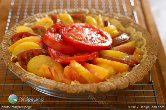 Fresh heirloom tomatoes (any good tomatoes work just as well) and herbs are baked on a bed of mozzarella cheese in a pie shell and topped with herbed garlic olive oil.