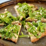Cheesy and Garlicky White Pizza topped with Fresh Arugula 