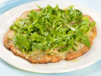 Cheesy and Garlicky White Pizza topped with Fresh Arugula 