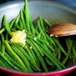 Heat up the green beans with the dressing