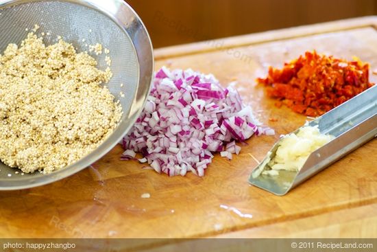 Rinse the quinoa and chop the onion, sun-dried tomatoes and garlic
