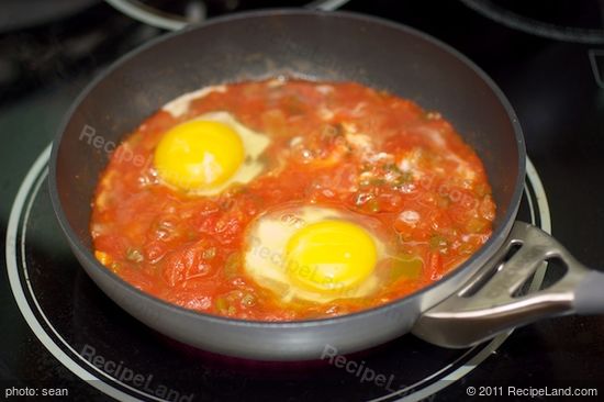 Crack eggs into the poaching liquid (the salsa)