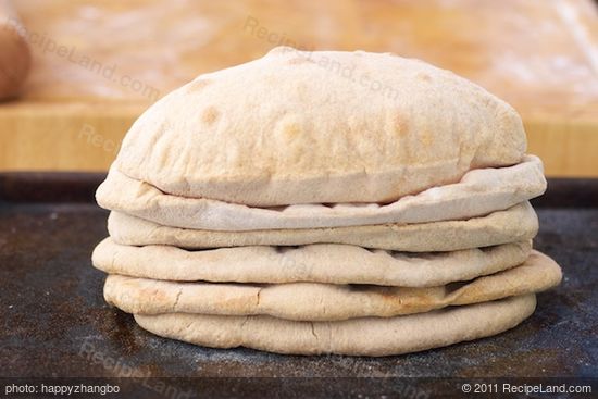 Stack baked naan bread together on a baking sheet...