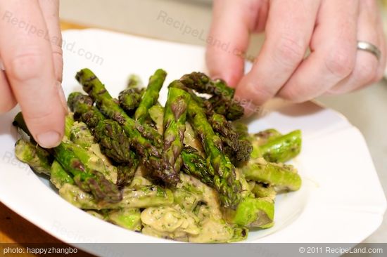 Arrange the tossed asparagus onto a serving platter,