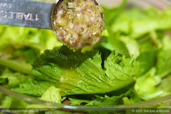 In a large bowl, add the mixed baby greens and 2 tablespoons of vinaigrette, toss until evenly coated.