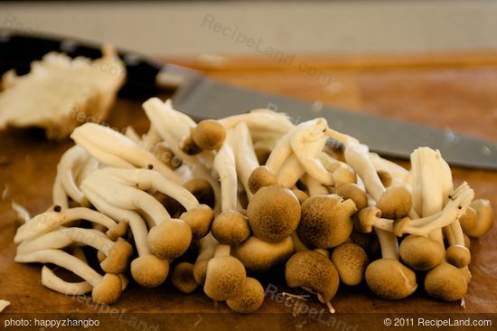 Trim off the ends of small brown mushrooms, then separate into pieces.