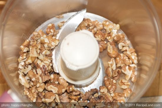 Add lightly toasted walnuts into a food processor.