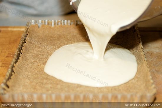 Pour the creamy filling into the baked tart shell.