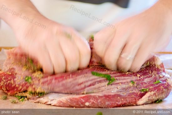 Tightly roll the stuffed flank steak lengthwise