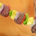 Thread each skewer with a pineapple chunk, three layers of onion (in one stack) and cube of beef.