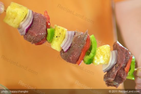 Thread each skewer with a pineapple chunk, three layers of onion (in one stack) and cube of beef.