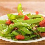 Add the snow peas, red bell pepper and garlic to a hot skillet with 1 tablespoon of vegetable oil added,