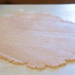 and roll the dough on a lightly floured working surface into a 14-inch circle.