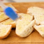 Brush the garlic-olive oil on each slice.
