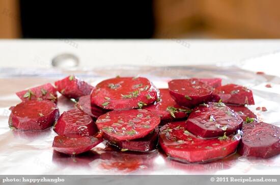 Toss beets in mixing bowl with garlic, thyme, balsamic vinegar, 2 tbsp olive oil and 1 tbsp lemon juice.