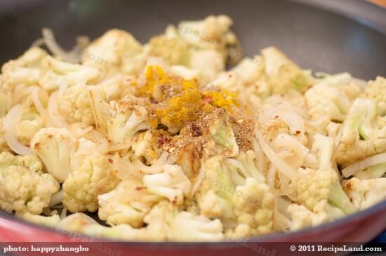 Add the spice mixture into partially cooked cauliflower and onion.