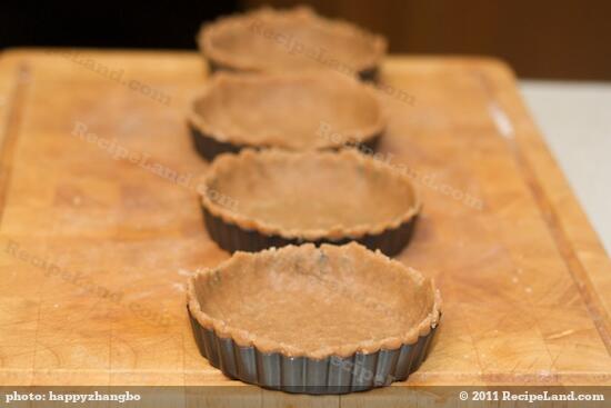 Using your fingers push the dough into the prepared tart pan, all the way up to the sides. 