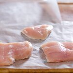 Place each chicken cutlet on waxed paper