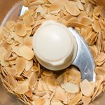 Add toasted almonds into food processor. 