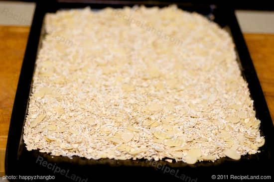 Place the oats, coconut, and almonds on a baking sheet, mix well and spread evenly. 