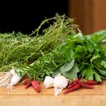 Wash well all the herbs, and let's work on chopping up the herbs, garlic and red chili peppers first.