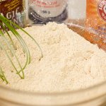 In a large bowl, whisk together the flours, corn meal, baking powder, baking soda and salt.