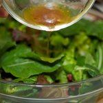 Gently toss the greens with the remaining dressing until well coated.
