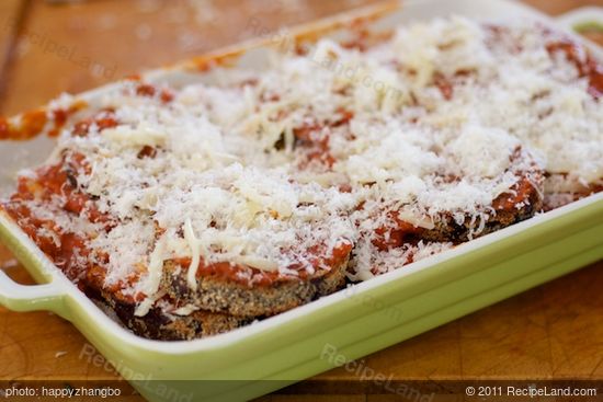 Lay another layer of eggplant slices, tomato sauce and two cheeses, repeat until all the ingredients have been used up. 