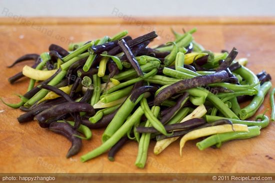 As the onions are cooking,  rinse, trim and halve the green beans.