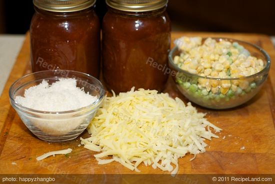 Next shred the mozzarella, grate the parmesan, get the frozen peas and tomato or marinara sauce ready.