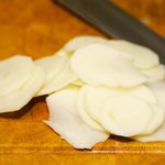 Thinly slice the potatoes, and put the slices into a large bowl of water.