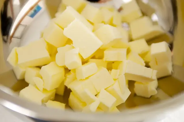 Cut the butter into small pieces and put into a large bowl.