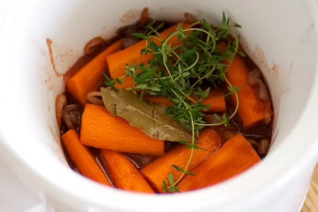 Add the carrots, bay leaf and thyme sprigs to the crock or pot.  